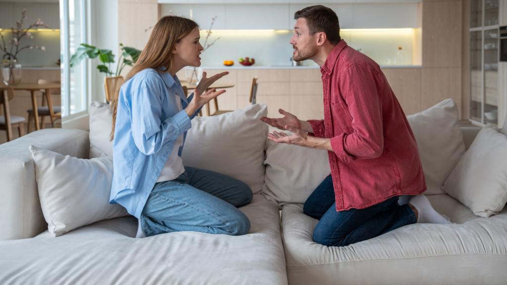Couple conflict with man and woman arguing on couch during heated relationship disagreement at home