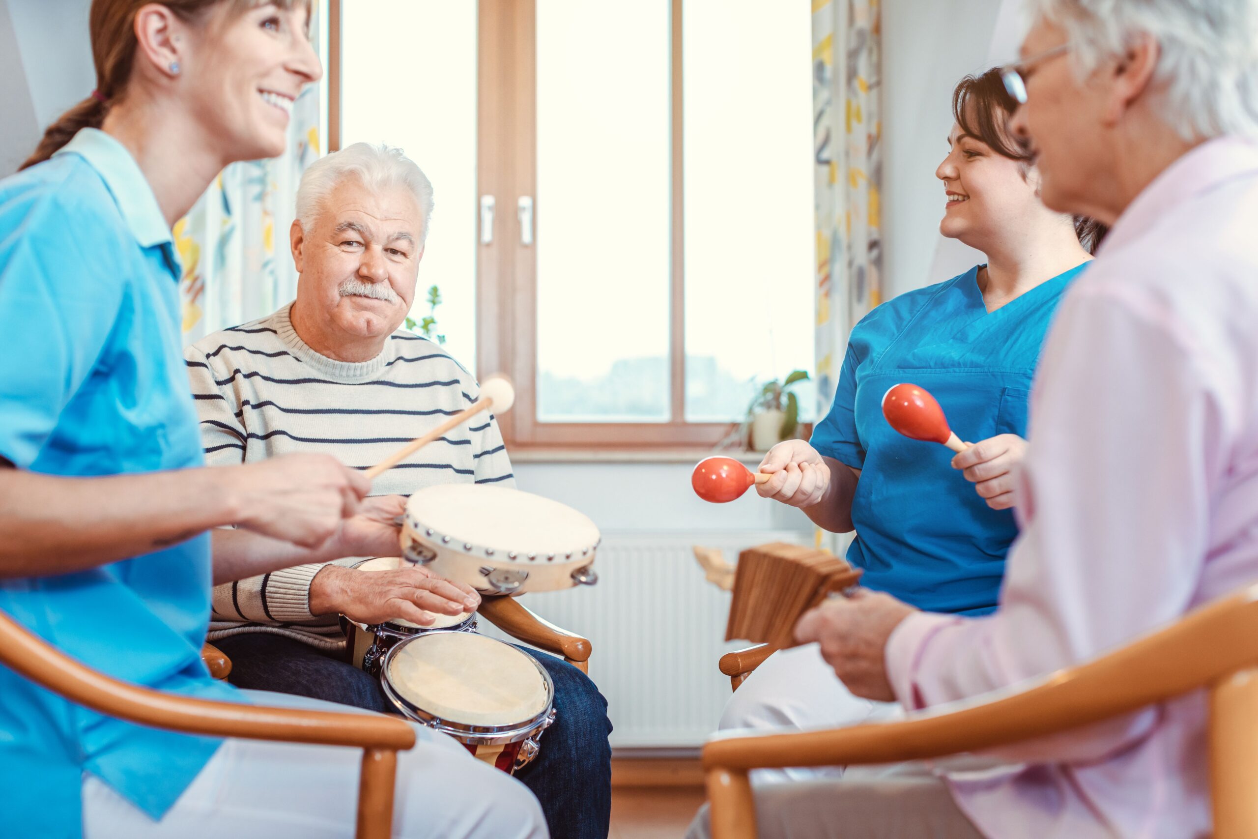 Adult participants playing percussion instruments together in a music therapy session focused on creativity, communication, and emotional well-being.